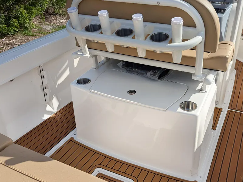 Slide: The Image of 2025 Bayliner Trophy T20CC boat interior with rod holders and cushioned seating. - 12