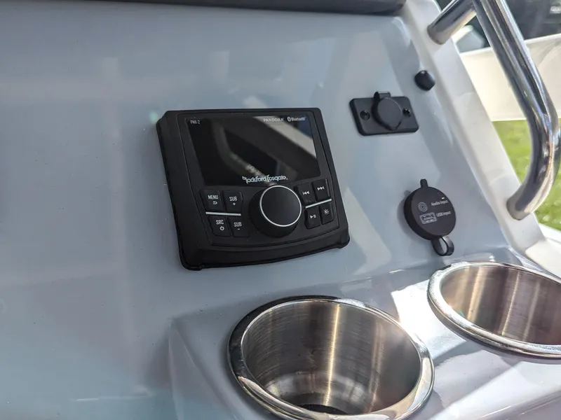 Slide: The Image of Control panel and cup holders on 2025 Bayliner Trophy T20CC boat dashboard. - 15