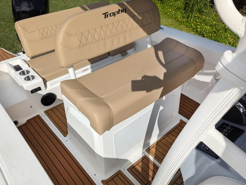 Slide: The Image of 2025 Bayliner Trophy T20CC boat interior with tan seating and wood-style flooring. - 8