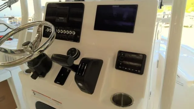 Slide: The Image of 2025 Sea Pro 210 Bay boat dashboard with steering wheel and electronic controls. - 11