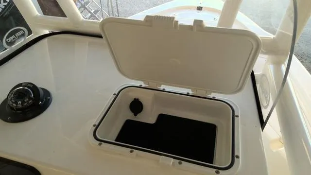 Slide: The Image of 2025 Sea Pro 210 Bay boat console with open storage compartment and compass. - 16