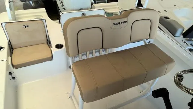 Slide: The Image of 2025 Sea Pro 210 Bay boat interior with beige seating and steering wheel. - 18