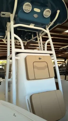 Slide: The Image of 2025 Sea Pro 210 Bay boat console with tan seating and blue canopy. - 3