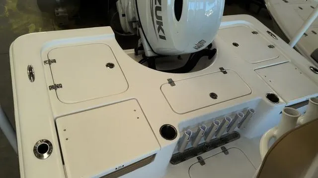 Slide: The Image of 2025 Sea Pro 210 Bay boat deck with Suzuki engine, featuring storage compartments and rod holders. - 6