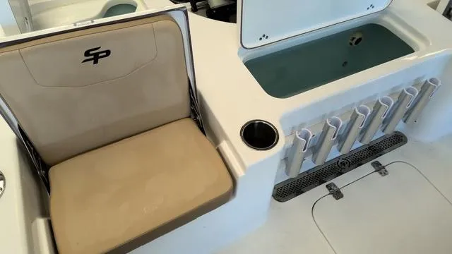 Slide: The Image of 2025 Sea Pro 210 Bay boat interior with seating, rod holders, and storage compartment. - 9