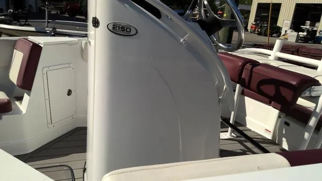 Slide: The Image of 2019 Tahoe 2150 CC boat interior with maroon seating and steering console. - 5