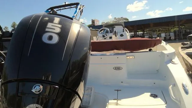 Slide: The Image of 2019 Tahoe 2150 CC boat with 150 HP engine, docked under clear skies. - 7