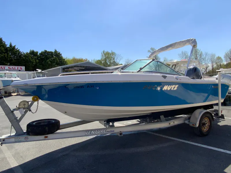 Slide: The Image of 2015 Tidewater 196 DC Explorer boat on trailer, blue and white design, parked outdoors. - 5
