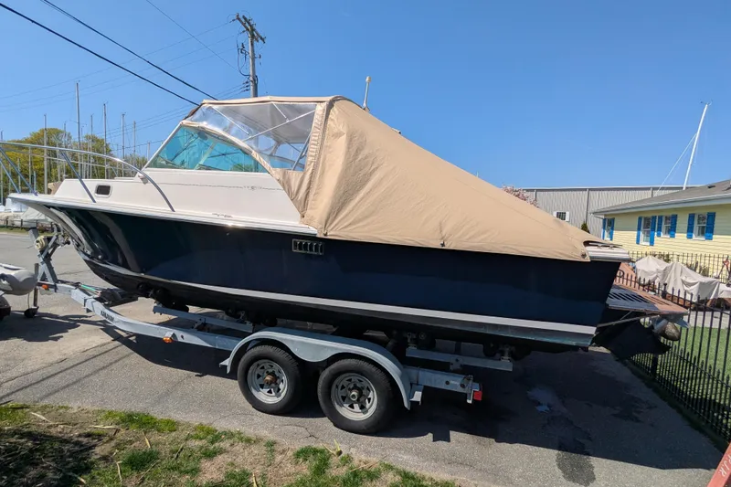 Slide: The Image of 2004 Hunt Yachts Surfhunter 25 on trailer, covered, parked outdoors. - 11