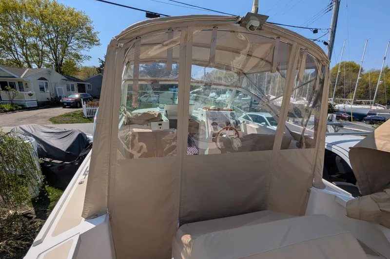 Slide: The Image of 2004 Hunt Yachts Surfhunter 25 with enclosed cockpit, docked in a marina setting. - 12