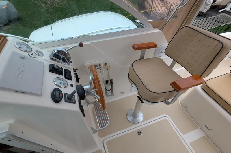 Slide: The Image of 2004 Hunt Yachts Surfhunter 25 helm with beige captain's chair and control panel. - 13