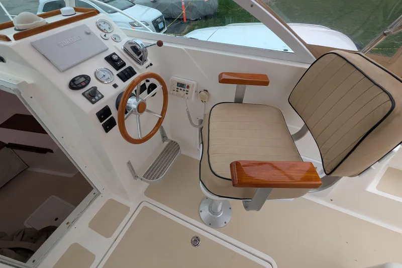 Slide: The Image of 2004 Hunt Yachts Surfhunter 25 helm with beige seating and wooden accents. - 14
