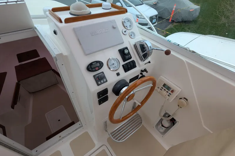 Slide: The Image of 2004 Hunt Yachts Surfhunter 25 helm with gauges, steering wheel, and control panel. - 15