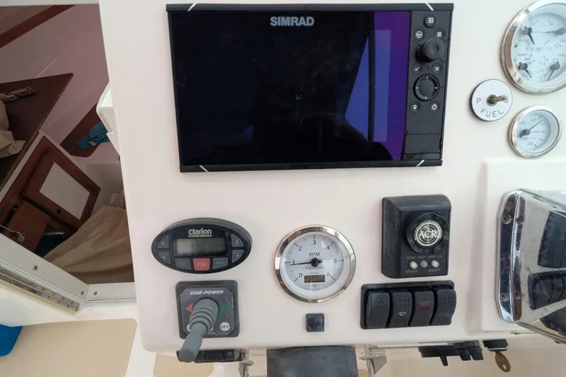 Slide: The Image of 2004 Hunt Yachts Surfhunter 25 dashboard with Simrad display and various controls. - 16