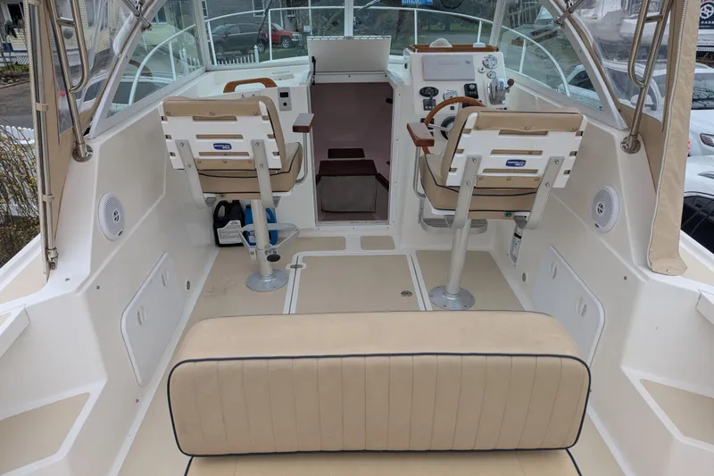 Slide: The Image of 2004 Hunt Yachts Surfhunter 25 interior with dual helm seats and beige upholstery. - 17