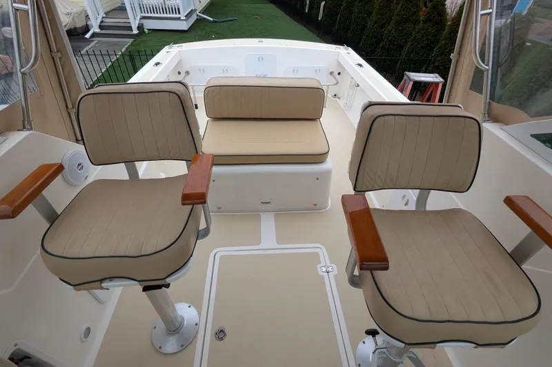 Slide: The Image of 2004 Hunt Yachts Surfhunter 25 interior with beige seating and wooden armrests. - 18