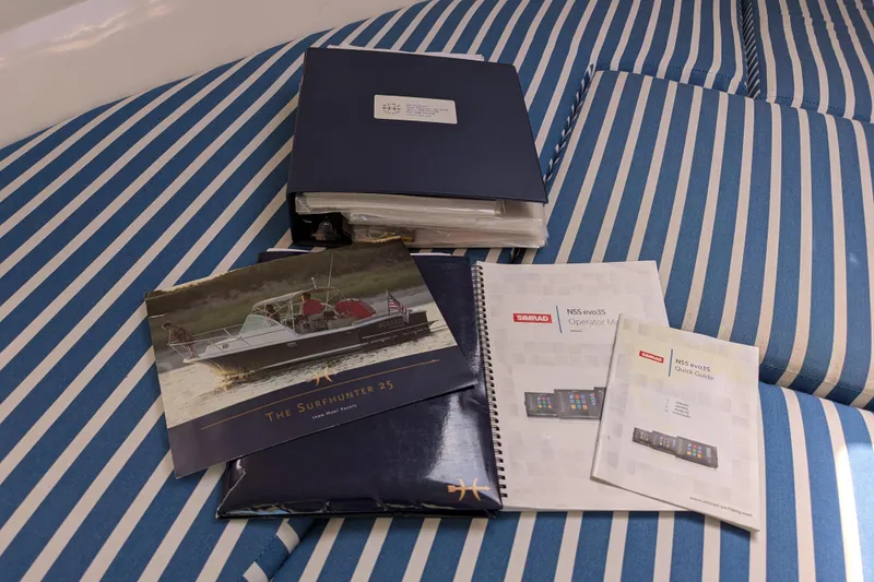 Slide: The Image of Documents and manuals for 2004 Hunt Yachts Surfhunter 25 on striped upholstery. - 26