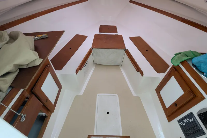 Slide: The Image of 2004 Hunt Yachts Surfhunter 25 cabin interior with wood accents and storage compartments. - 30