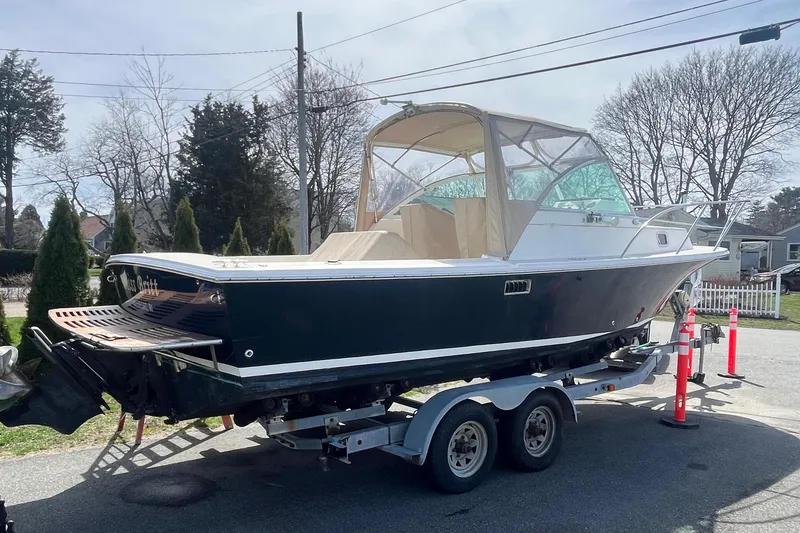 Slide: The Image of 2004 Hunt Yachts Surfhunter 25 on trailer, parked outdoors, with protective canopy. - 9