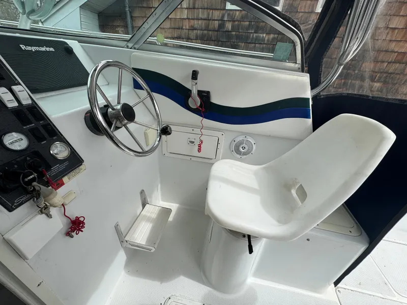 Slide: The Image of 2000 Seaswirl Striper WALKAROUND boat cockpit with steering wheel and captain's chair. - 11
