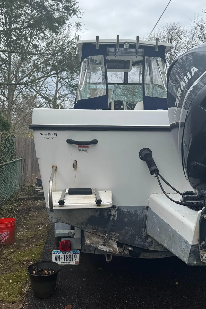 Slide: The Image of 2000 Seaswirl Striper WALKAROUND boat, rear view, parked outdoors with Yamaha motor. - 14