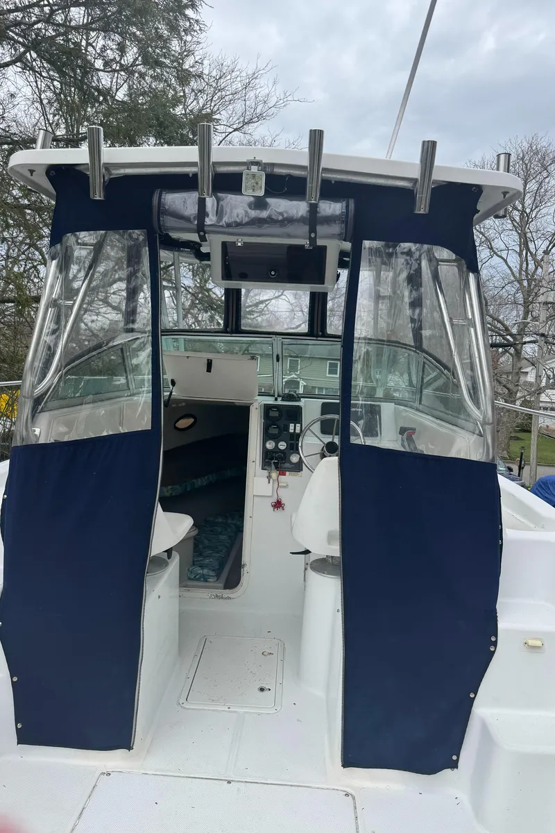 Slide: The Image of 2000 Seaswirl Striper WALKAROUND boat with blue canvas cover and open cockpit view. - 15