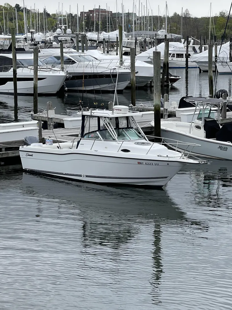 Slide: The Image of 2000 Seaswirl Striper WALKAROUND boat docked in a marina with other vessels. - 2