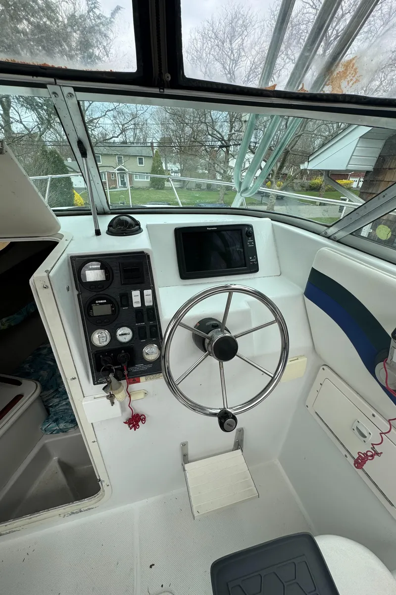 Slide: The Image of 2000 Seaswirl Striper WALKAROUND boat cockpit with steering wheel and control panel. - 21