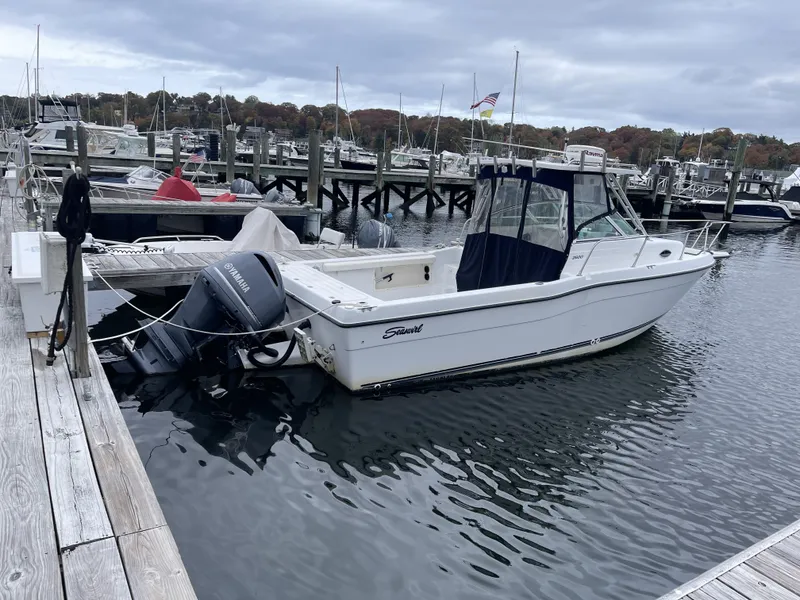 Slide: The Image of 2000 Seaswirl Striper WALKAROUND boat docked in a marina under cloudy skies. - 3