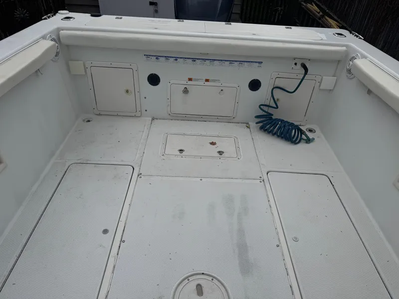 Slide: The Image of 2000 Seaswirl Striper WALKAROUND boat deck with storage compartments and coiled hose. - 7