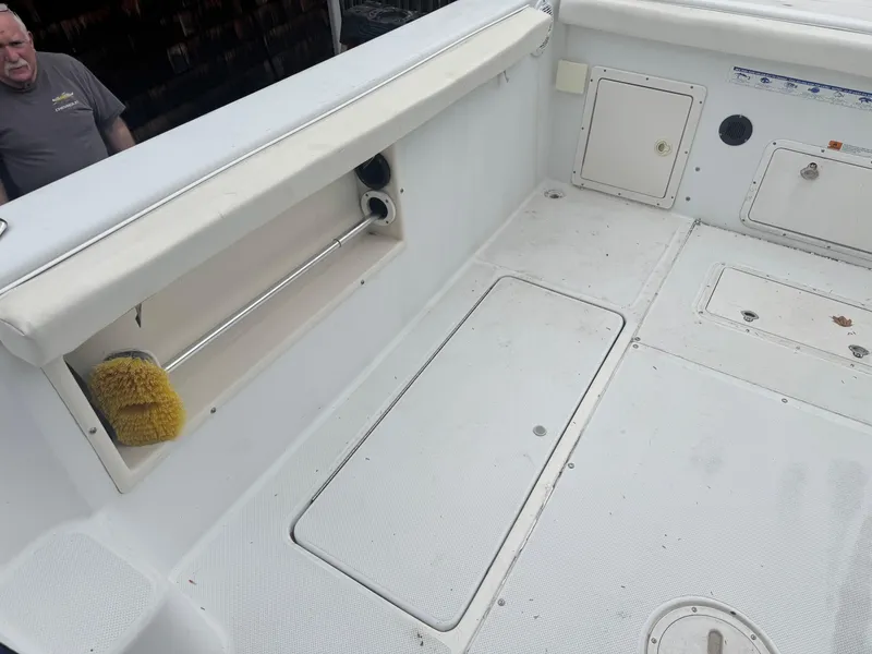 Slide: The Image of 2000 Seaswirl Striper WALKAROUND boat deck with storage compartments and cleaning brush. - 8