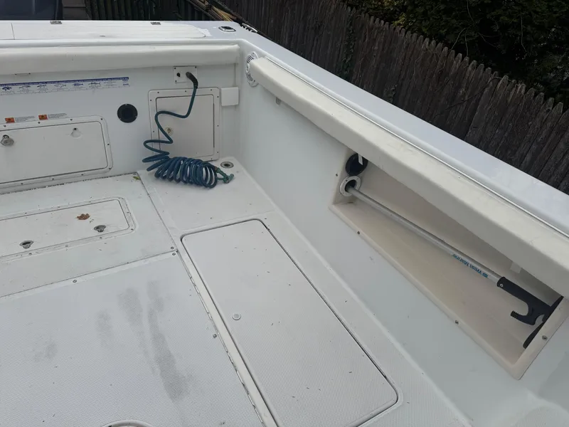 Slide: The Image of 2000 Seaswirl Striper WALKAROUND boat deck with storage compartments and coiled hose. - 9