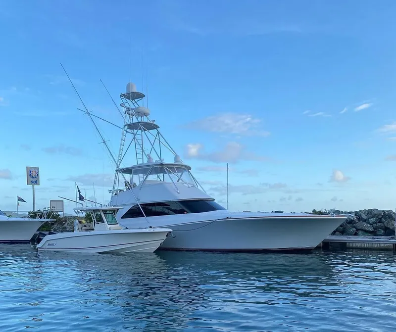 The Image of 2001 Viking 55 Convertible yacht docked in calm waters under a clear blue sky. - 0