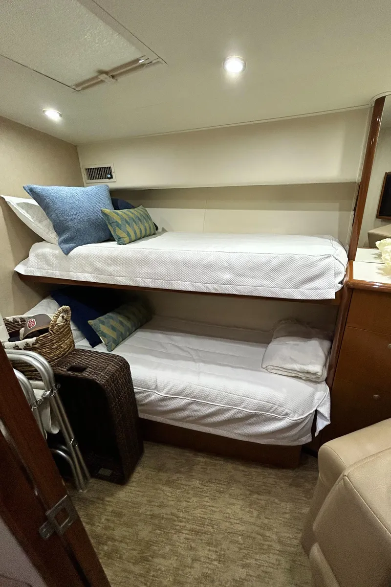Slide: The Image of Bunk beds in 2001 Viking 55 Convertible yacht cabin, featuring cozy bedding and storage. - 12