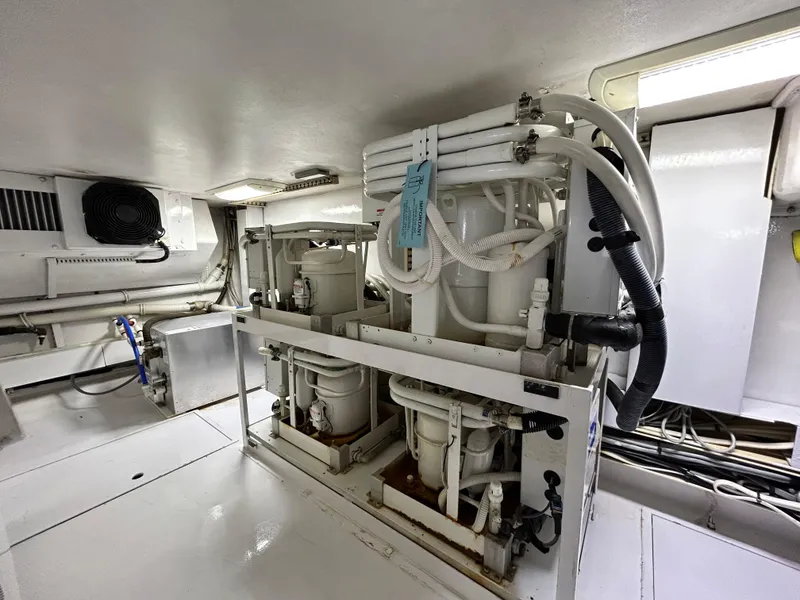 Slide: The Image of Engine room of 2001 Viking 55 Convertible yacht, featuring mechanical equipment and piping. - 21