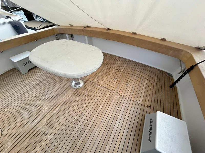 Slide: The Image of 2001 Viking 55 Convertible yacht deck with wooden flooring and round table. - 28