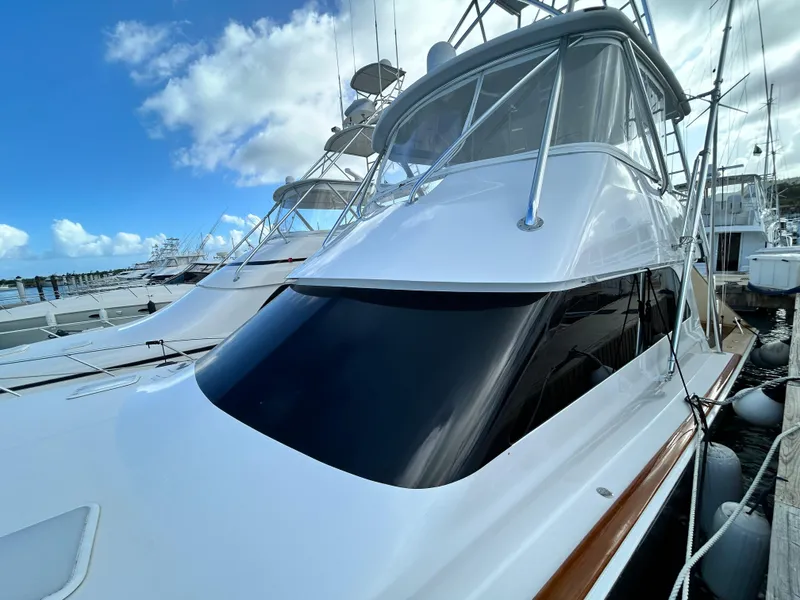 Slide: The Image of 2001 Viking 55 Convertible yacht docked under a clear blue sky. - 33