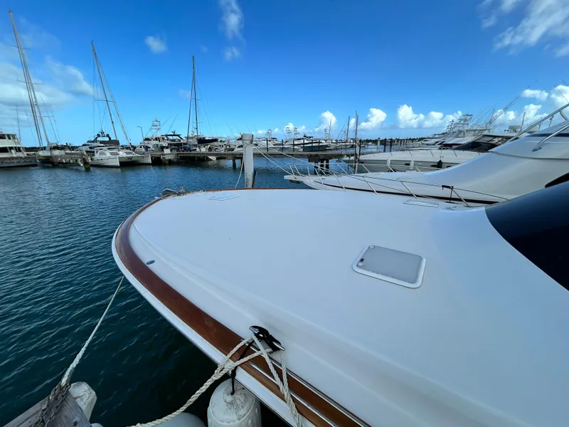Slide: The Image of 2001 Viking 55 Convertible yacht docked in a marina under a clear blue sky. - 34