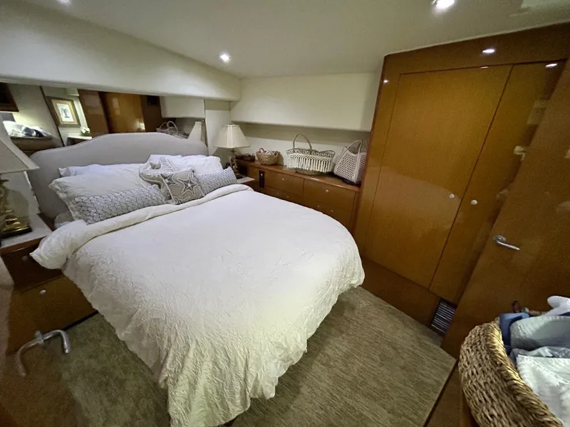 Slide: The Image of Luxurious bedroom interior of 2001 Viking 55 Convertible yacht with cozy bedding and wooden cabinetry. - 6