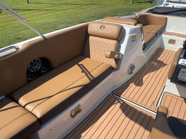 Slide: The Image of 2023 Crownline E225 XS boat interior with tan seating and teak flooring. - 10