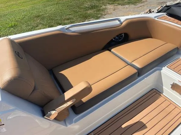 Slide: The Image of 2023 Crownline E225 XS boat interior with tan seating and wood accents. - 11