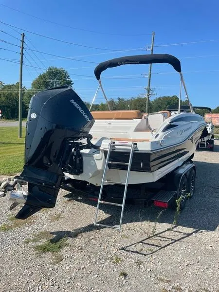 Slide: The Image of 2023 Crownline E225 XS boat with Mercury outboard engine on a trailer. - 2
