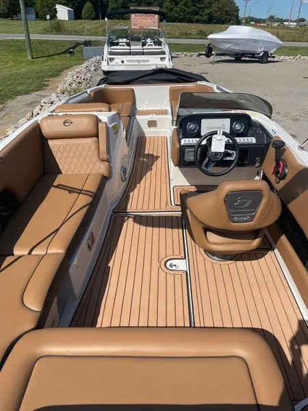 Slide: The Image of 2023 Crownline E225 XS boat interior with tan seating and modern dashboard. - 4