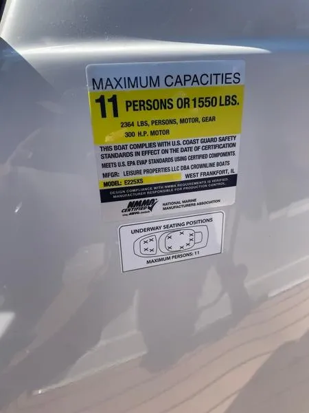 Slide: The Image of 2023 Crownline E225 XS capacity label: 11 persons or 1550 lbs, 300 HP motor. - 6