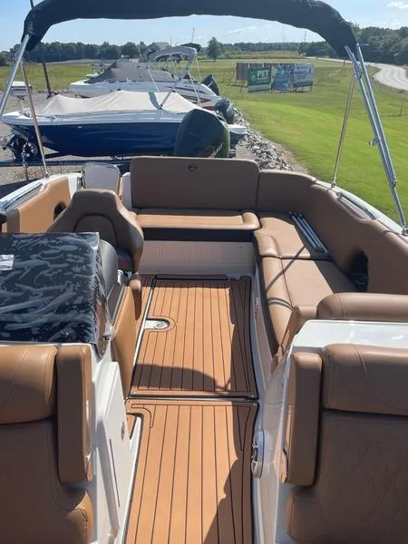 Slide: The Image of 2023 Crownline E225 XS boat interior with tan seating and teak flooring. - 8
