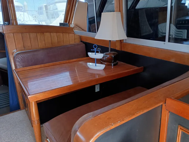 Slide: The Image of Cozy 1978 Pacific Bluefin SPF boat interior with wooden table, lamp, and seating. - 13