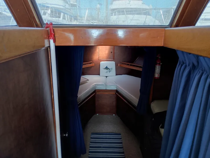 Slide: The Image of Interior cabin of a 1978 Pacific Bluefin SPF boat with cozy bedding and blue curtains. - 17