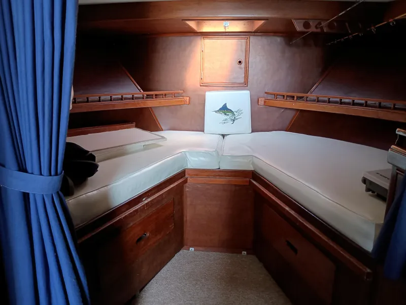 Slide: The Image of Cozy cabin interior of 1978 Pacific Bluefin SPF boat with wooden furnishings and blue curtains. - 19