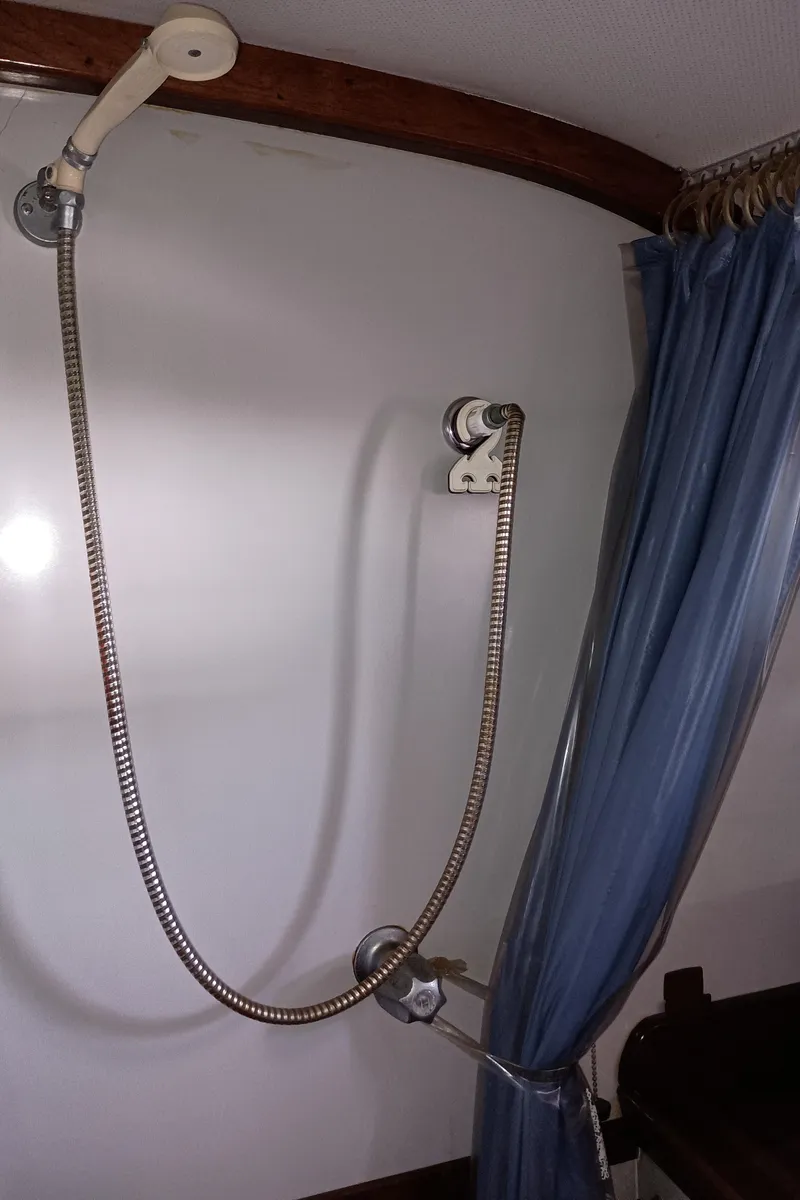 Slide: The Image of 1978 Pacific Bluefin SPF boat shower with blue curtain and handheld showerhead. - 23