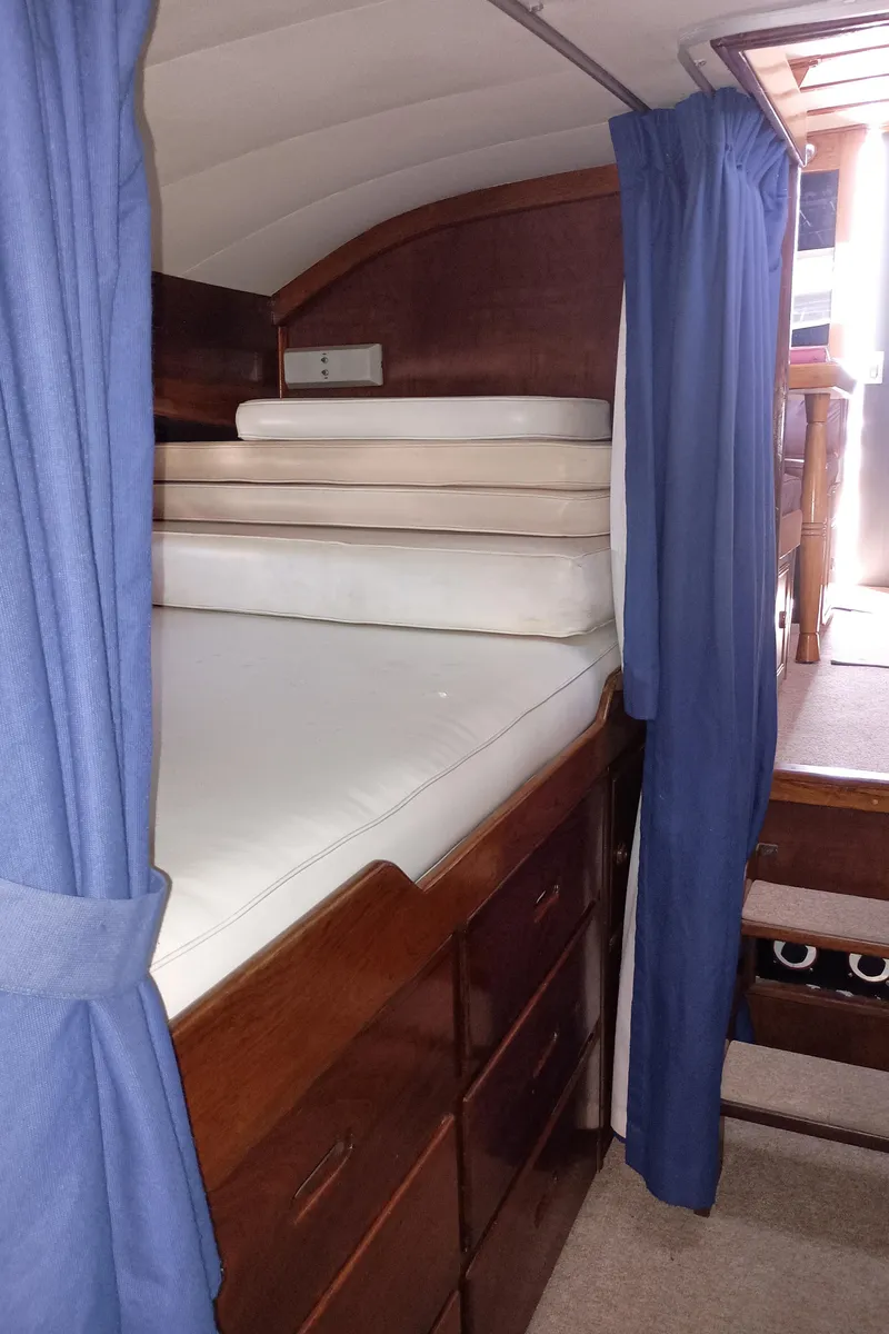 Slide: The Image of Cozy cabin interior of 1978 Pacific Bluefin SPF boat with wooden furnishings and blue curtains. - 26